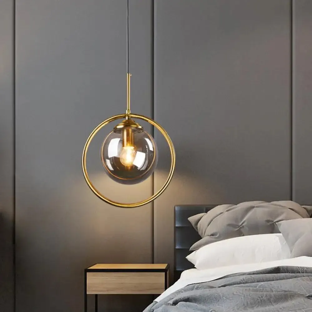 Postmodern Glass Pendant Light with Brass Ring for Bedroom - Single-Bulb Globe Down Lighting in Clear, Amber, and Smoke Grey