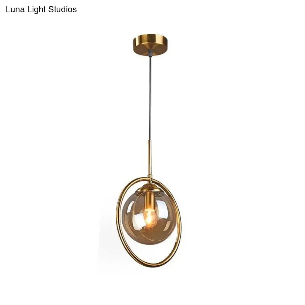 Postmodern Glass Pendant Light with Brass Ring for Bedroom - Single-Bulb Globe Down Lighting in Clear, Amber, and Smoke Grey