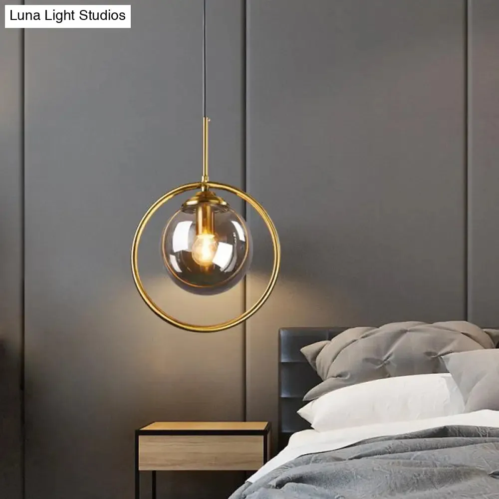 Postmodern Glass Pendant Light with Brass Ring for Bedroom - Single-Bulb Globe Down Lighting in Clear, Amber, and Smoke Grey